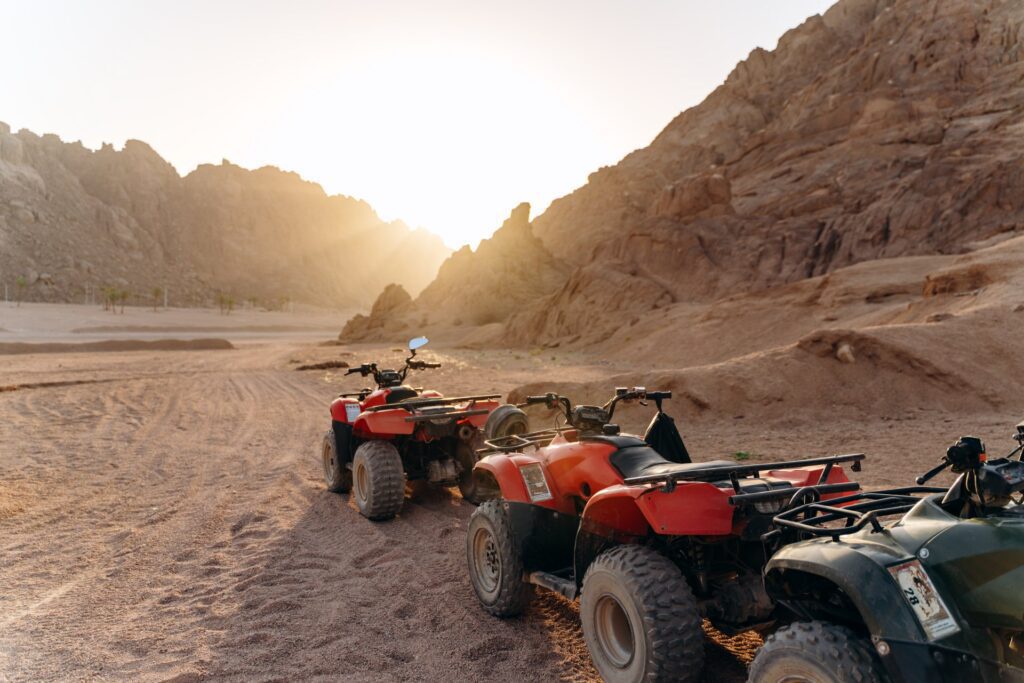column of atvs in the desert at sunset sunny desert