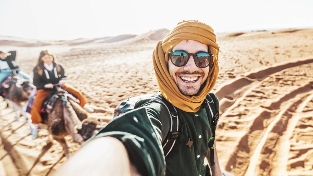 happy tourist having fun enjoying group camel ride
